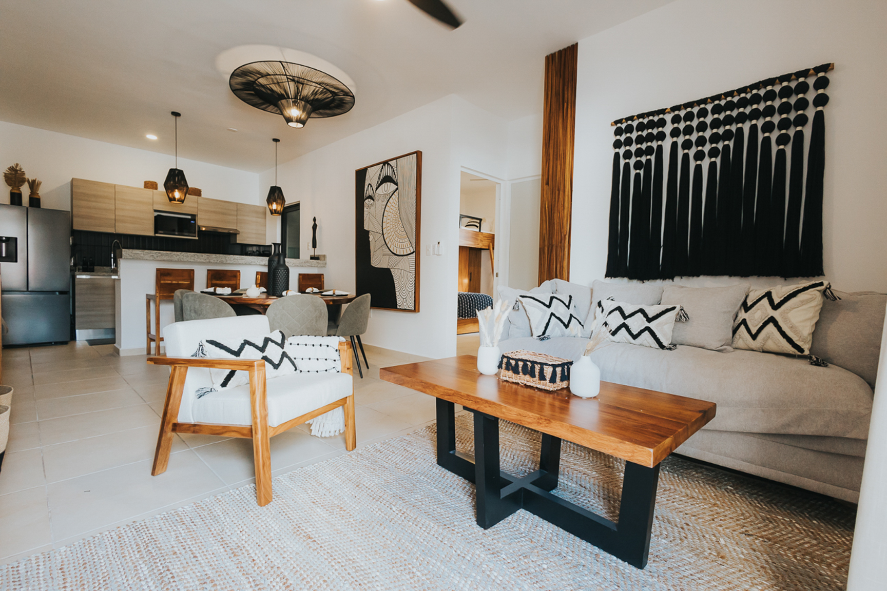 Casa Rocca — black and ivory living room with woven pendant, artisan textiles and tzalam table