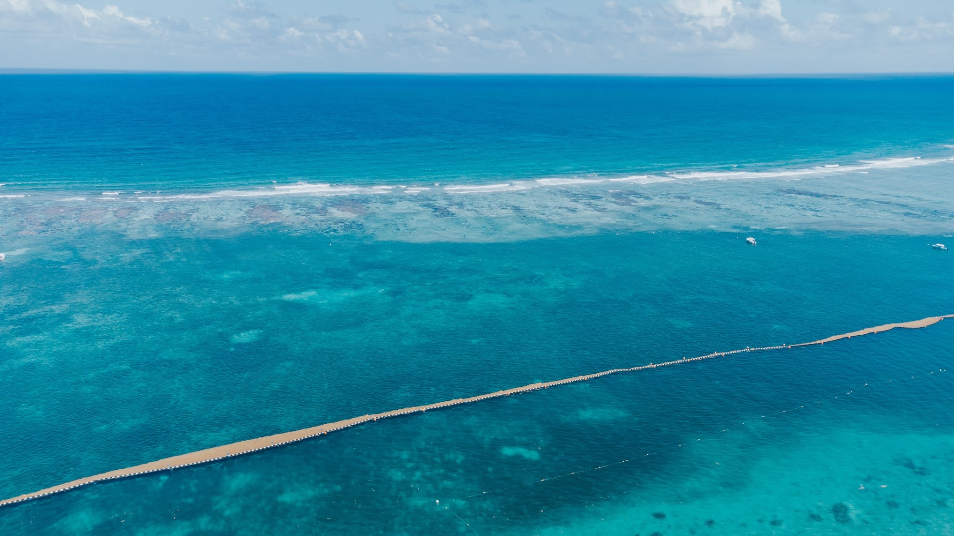 Aerial view of the Puerto Morelos reef with turquoise Caribbean water and breaking waves on the barrier reef